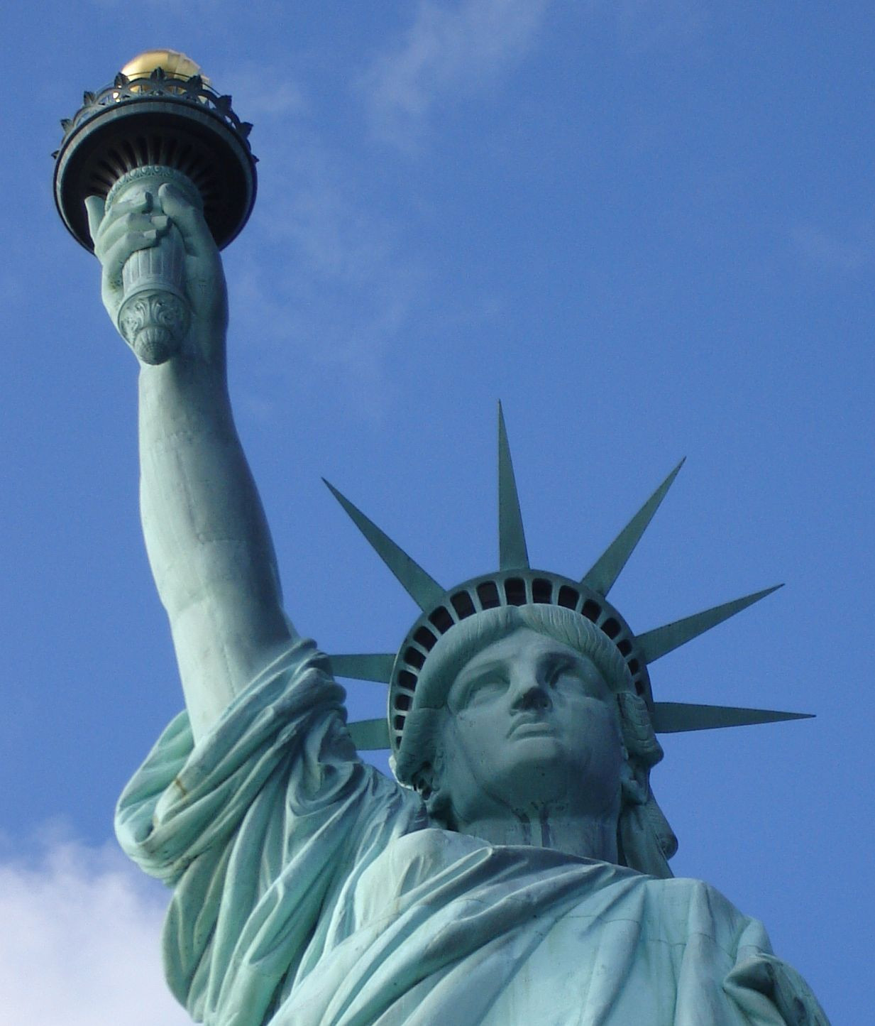 Statue of Liberty torch and crown against blue sky — historic image