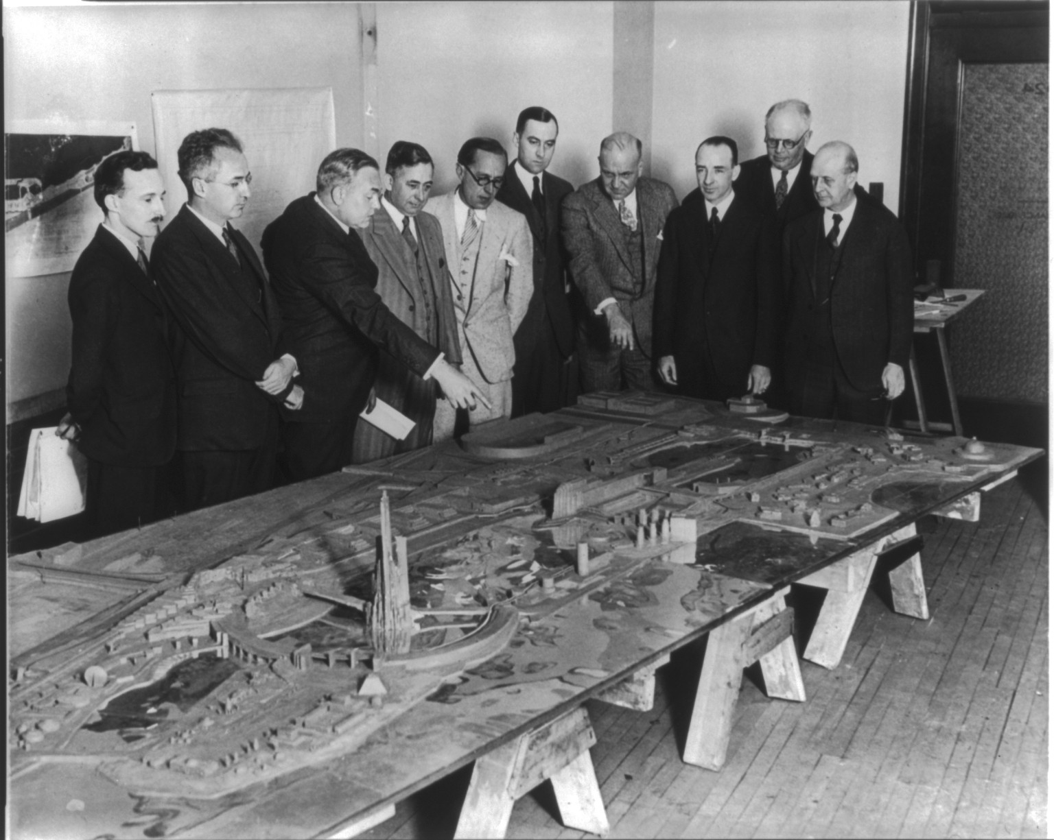 Architects and amusement consultants meet to examine clay model of Worlds Fair, 1930 May 21. — historic photograph