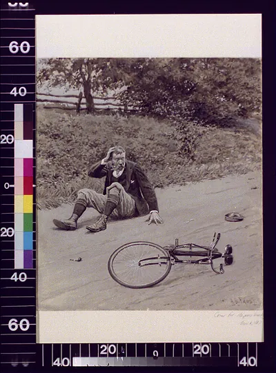 Man sprawled on road beside overturned bicycle