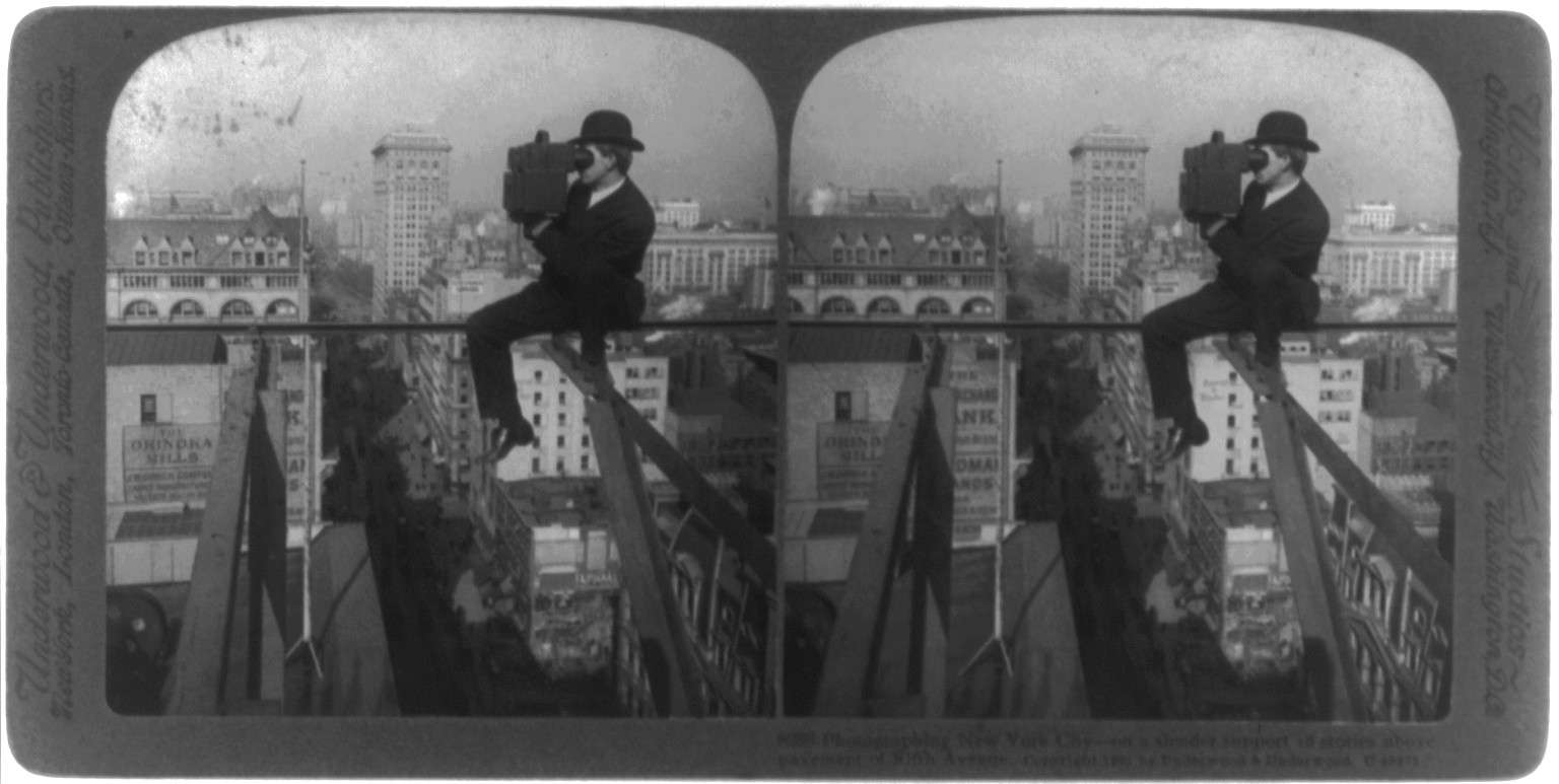 Photographing New York City - on a slender support 18 stories above pavement of Fifth Avenue, c1907. — historic photograph
