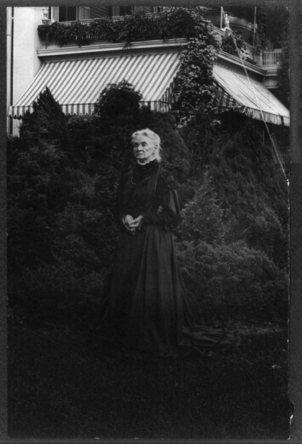 Gertrude McCurdy Hubbard, full length portrait standing in the yard at Twin Oaks" D.C. home of the Gardiner Greene Hubbard family", [ca. 1905] — historic photograph