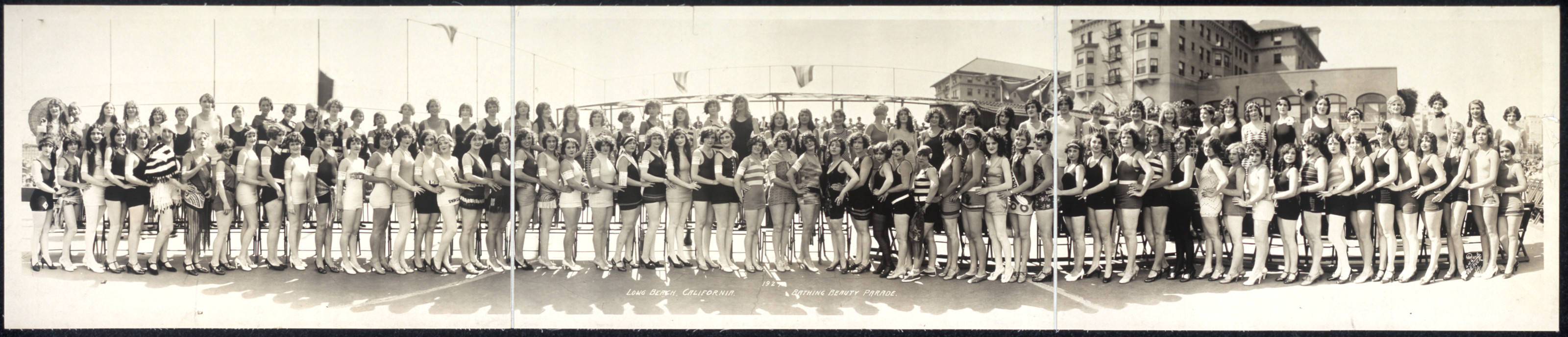 Panoramic group photograph of women in swimsuits on a beach — historic photograph
