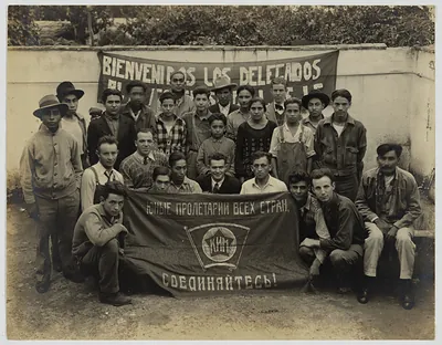 Young men posing with welcome banner and KIM flag