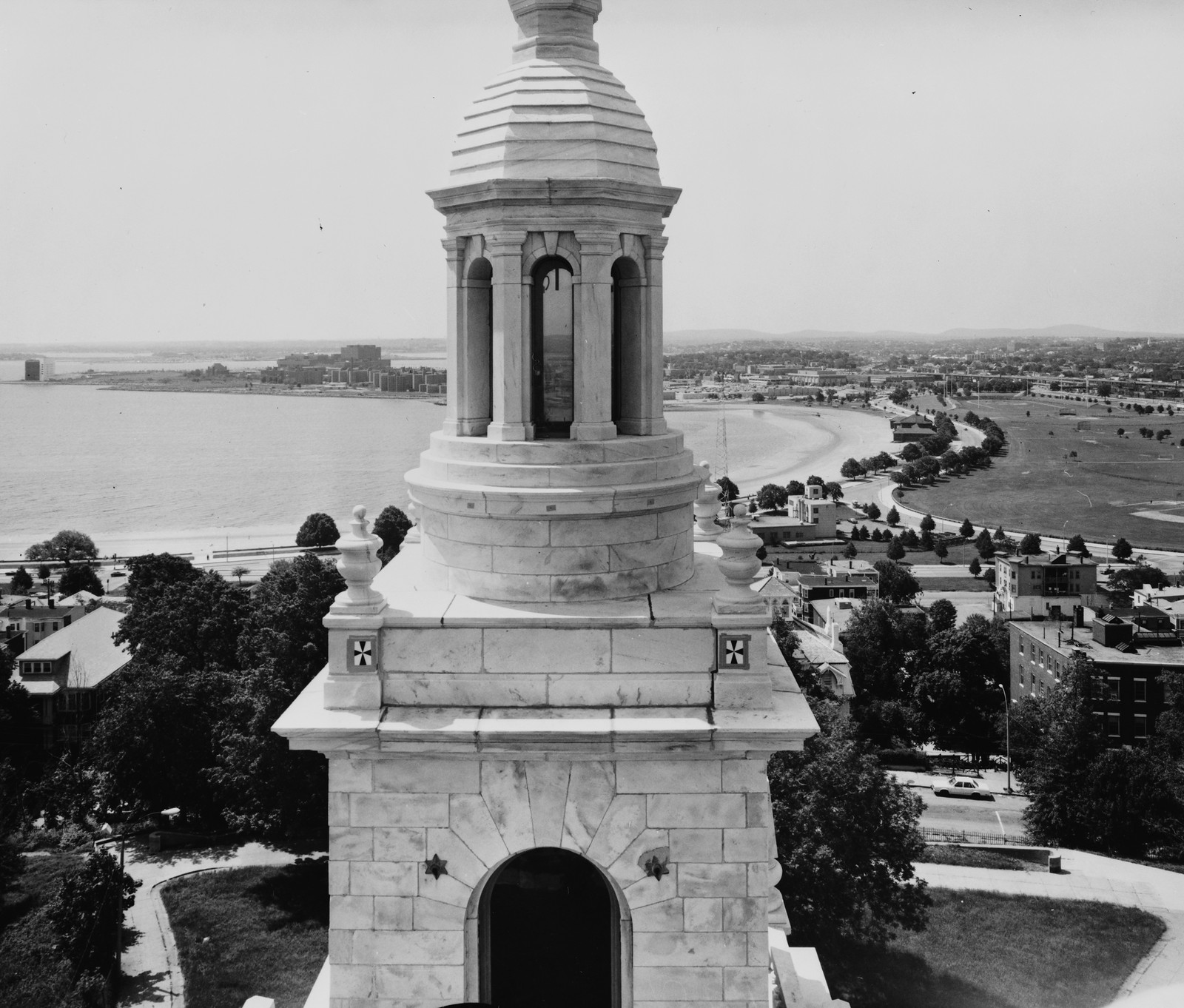 Marble monument tower top with lantern over harbor — historic image