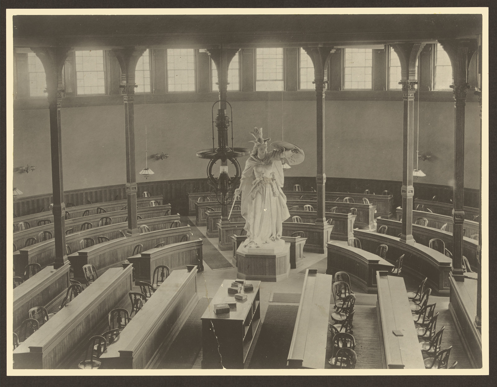 Sepia photograph of lecture hall interior with white statue — historic photograph