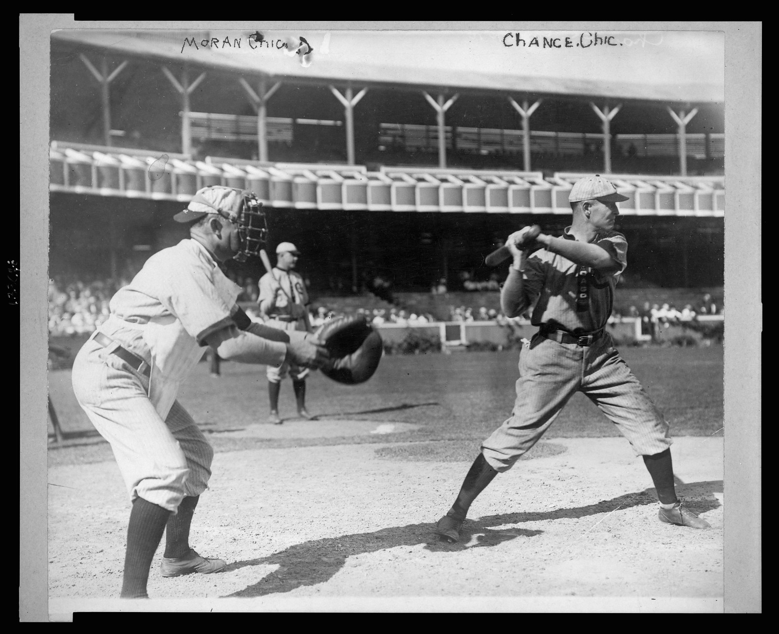[Frank Chance, Chicago NL baseball player, standing at home plate, with bat in hand about to swing, the catcher, Pat Moran, Chicago NL, stands to the left ready to receive the pitched ball], [1909] — historic photograph