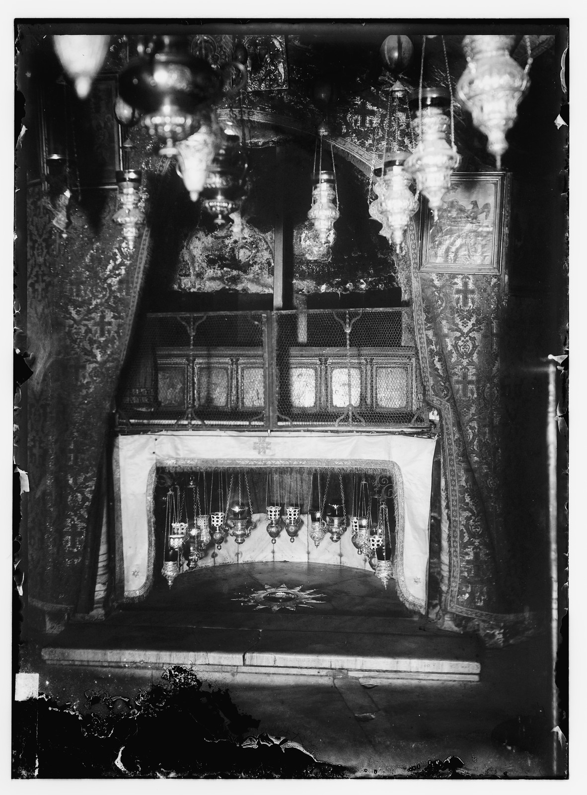 Ornate church interior with hanging lamps and a silver star — historic image