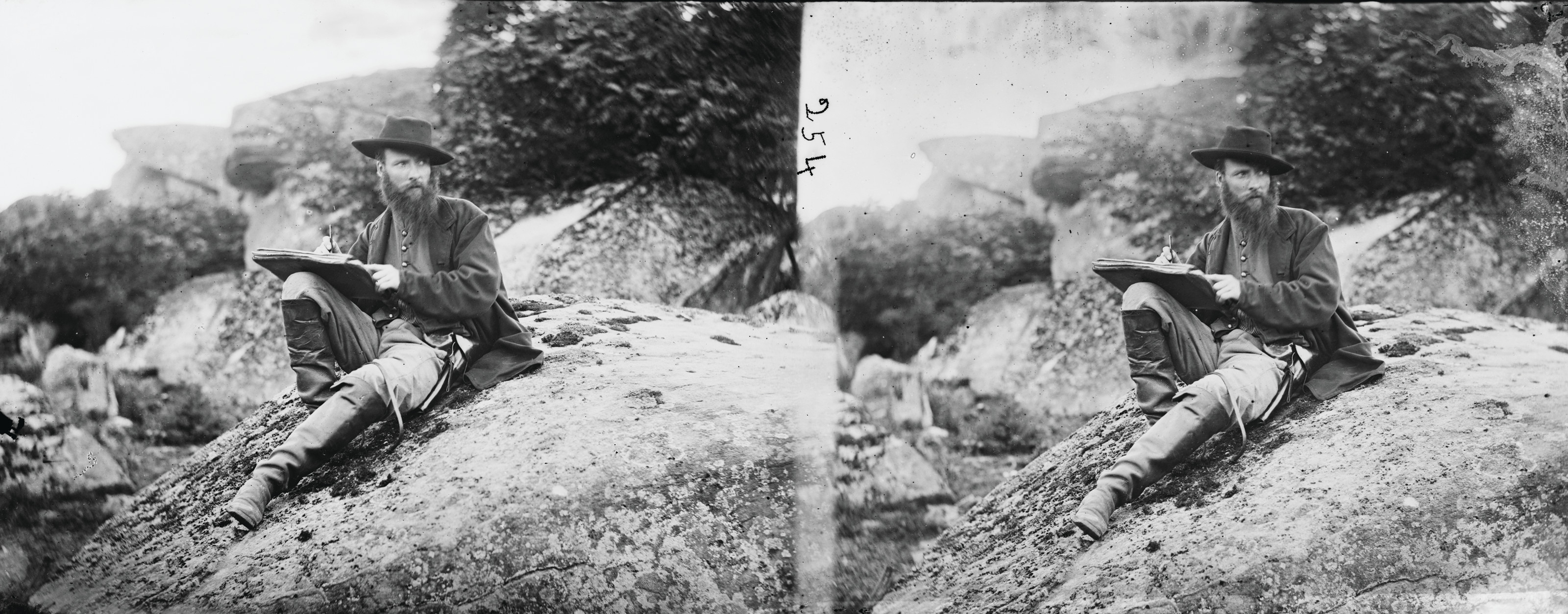 Bearded man with sketchbook seated on rocks, stereo photograph — historic photograph