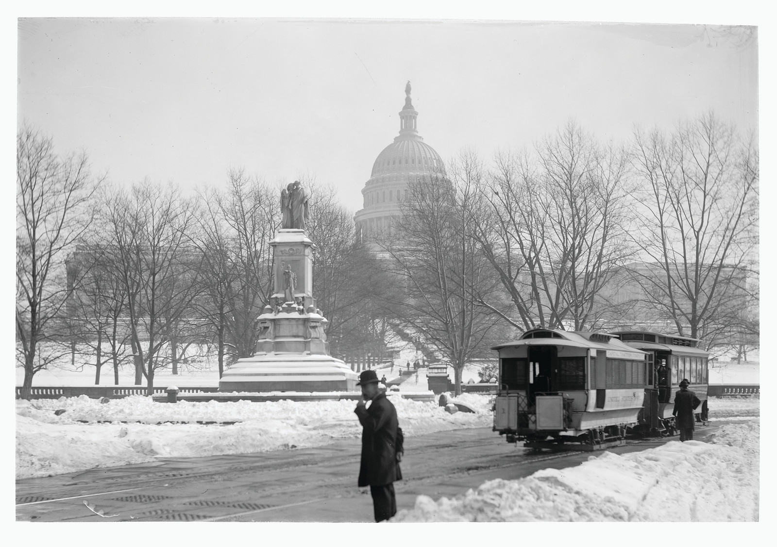 Snow-covered Capitol dome with streetcar and monument, winter photograph — historic photograph
