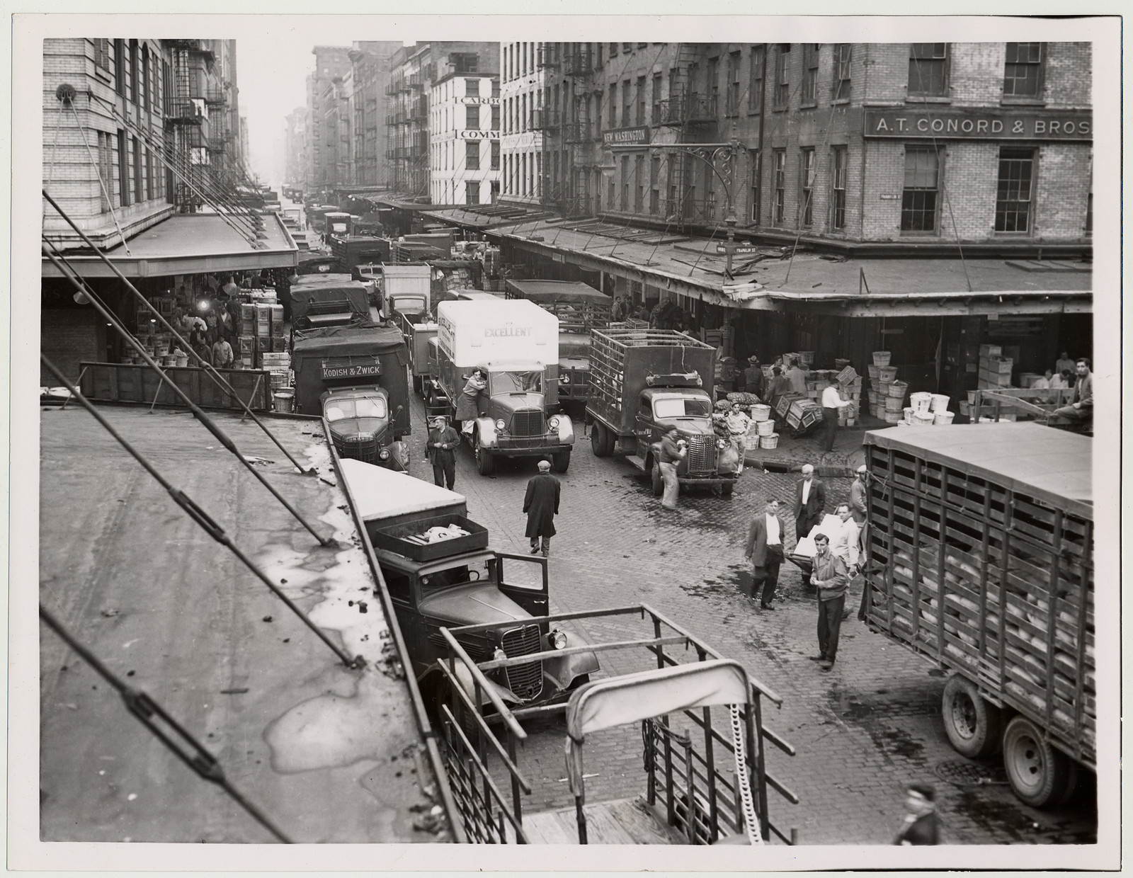 Trucks lined up on a cobbled city street — historic image