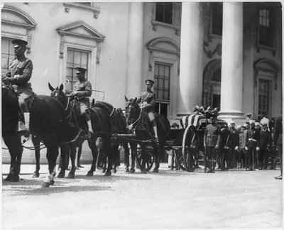 [Warren G. Harding, casket, on horse-drawn caisson surrounded by military honor guard and pall bearers - at White House entrance]