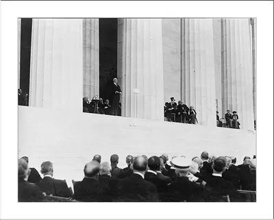 Speaker on Lincoln Memorial steps before a seated crowd