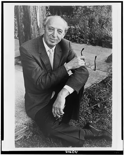 [Aaron Copland, full-length portrait, seated, outdoors, facing front] / Margery Smith.