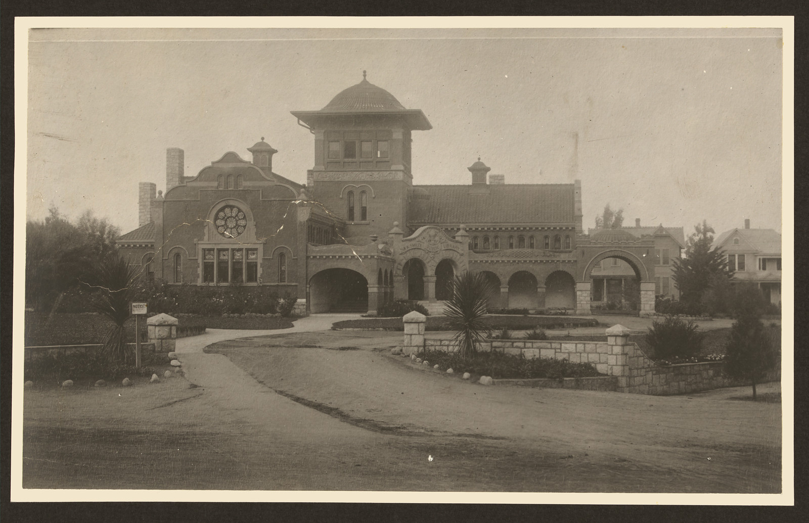 Brick public library building with rose window and tower — historic image