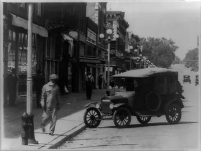 [Street view with automobile parked in foreground, Kingman, Kansas]