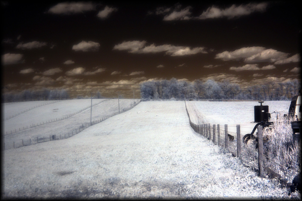 Infrared photograph of a field, fence and farm machinery — historic photograph