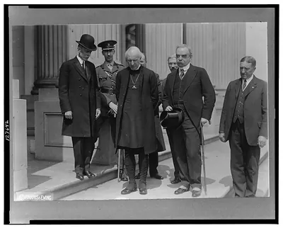 [Cosmo Gordon Lang, Archbishop of York, Major Crawford Stuart and five others, full-length portrait standing on sidewalk]