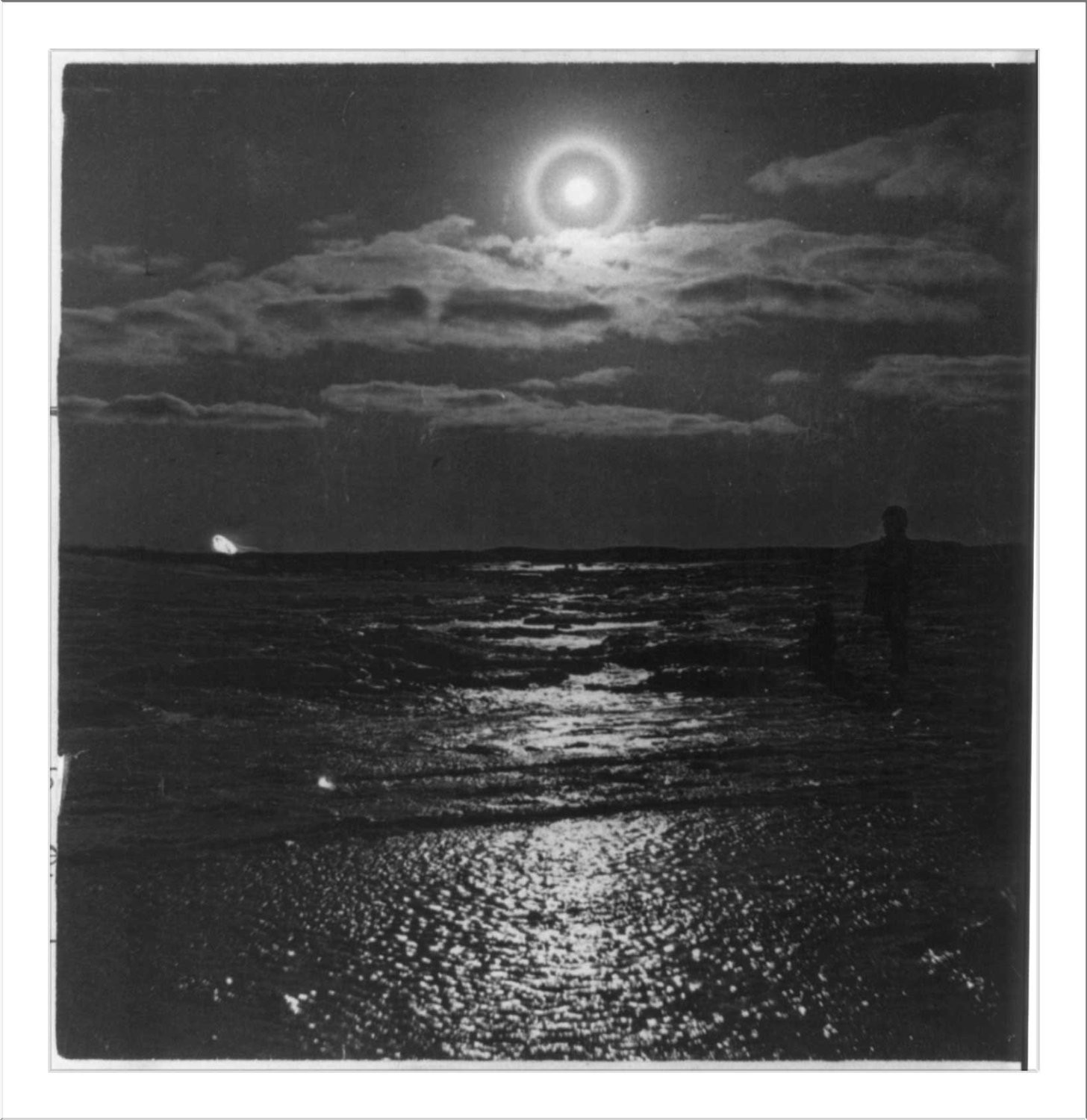 Moonlit sea with halo and silhouetted figure — historic image