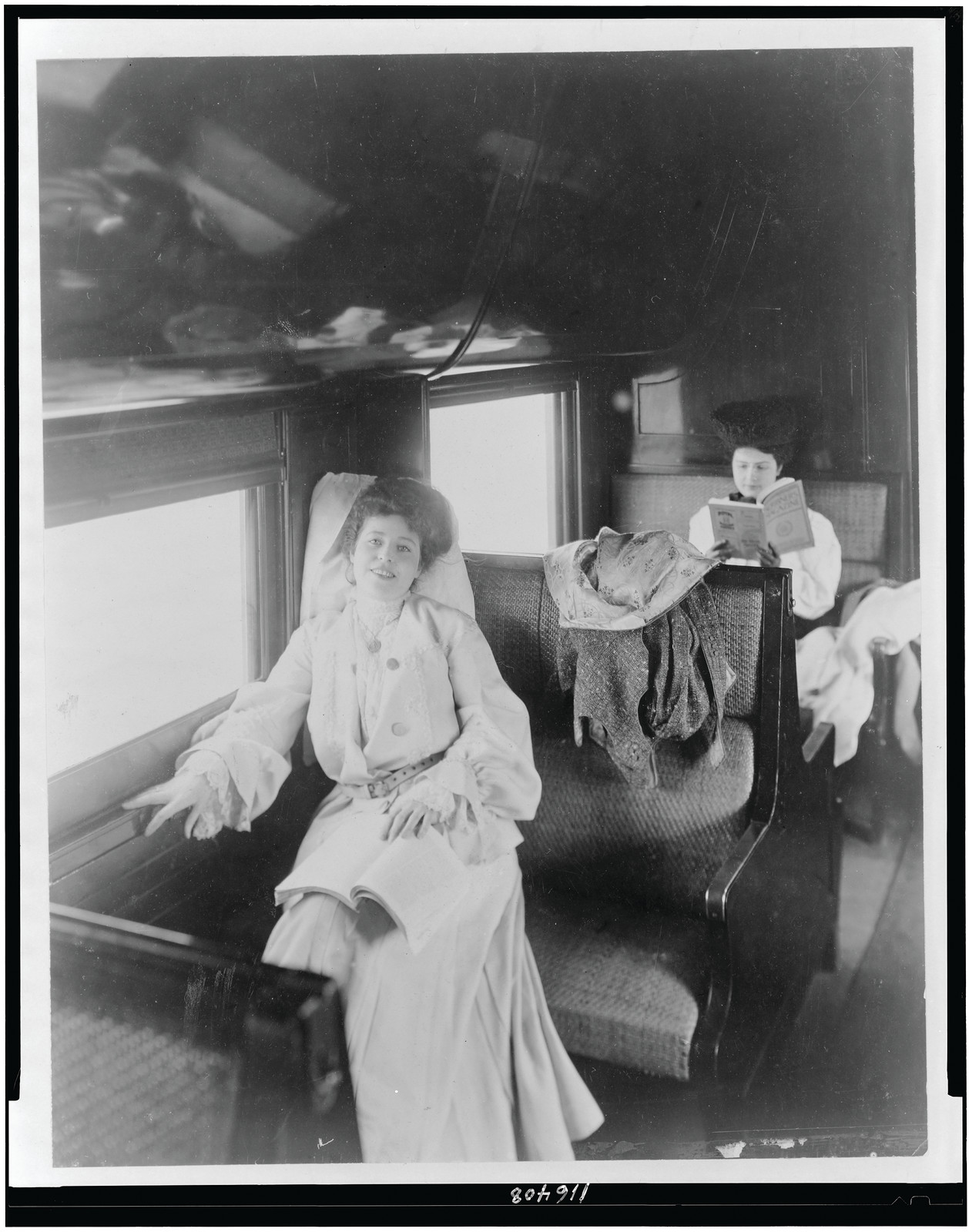 [Two women reading in railroad passenger car], c1905. — historic photograph