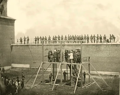 Wooden execution scaffold with crowd and soldiers on wall