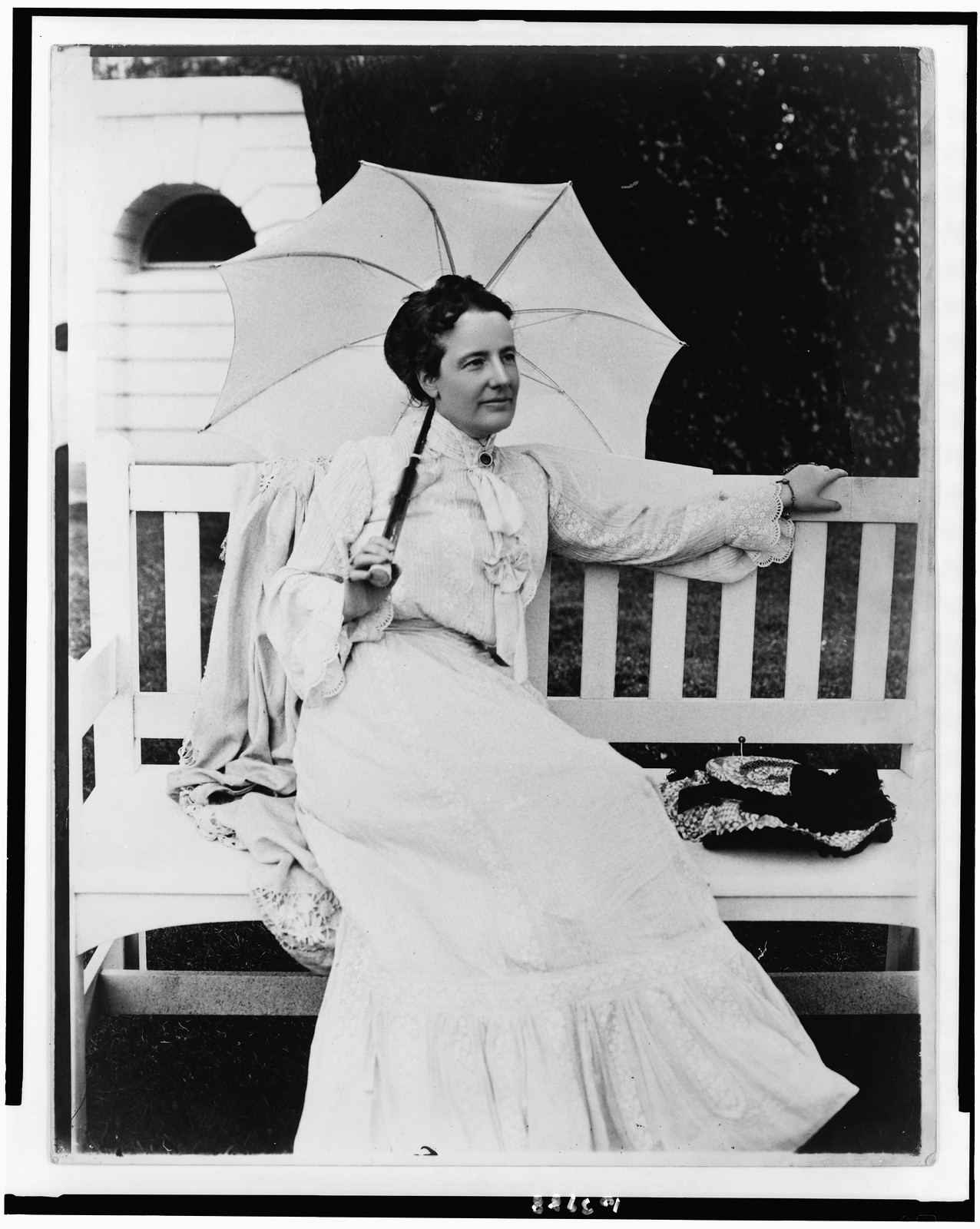 [Edith Kermit Carow Roosevelt, full-length portrait, seated on bench, facing right, holding umbrella], [between 1890 and ca. 1916] — historic photograph