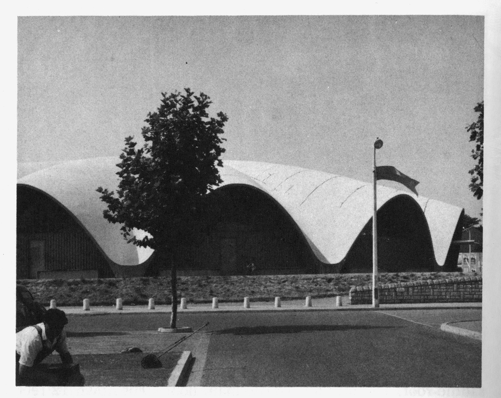 Modern building with undulating concrete roof and flagpole — historic image