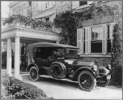 Automobile owned by Mrs. Charles W. Richardson in driveway with driver at the wheel, Washington, D.C.