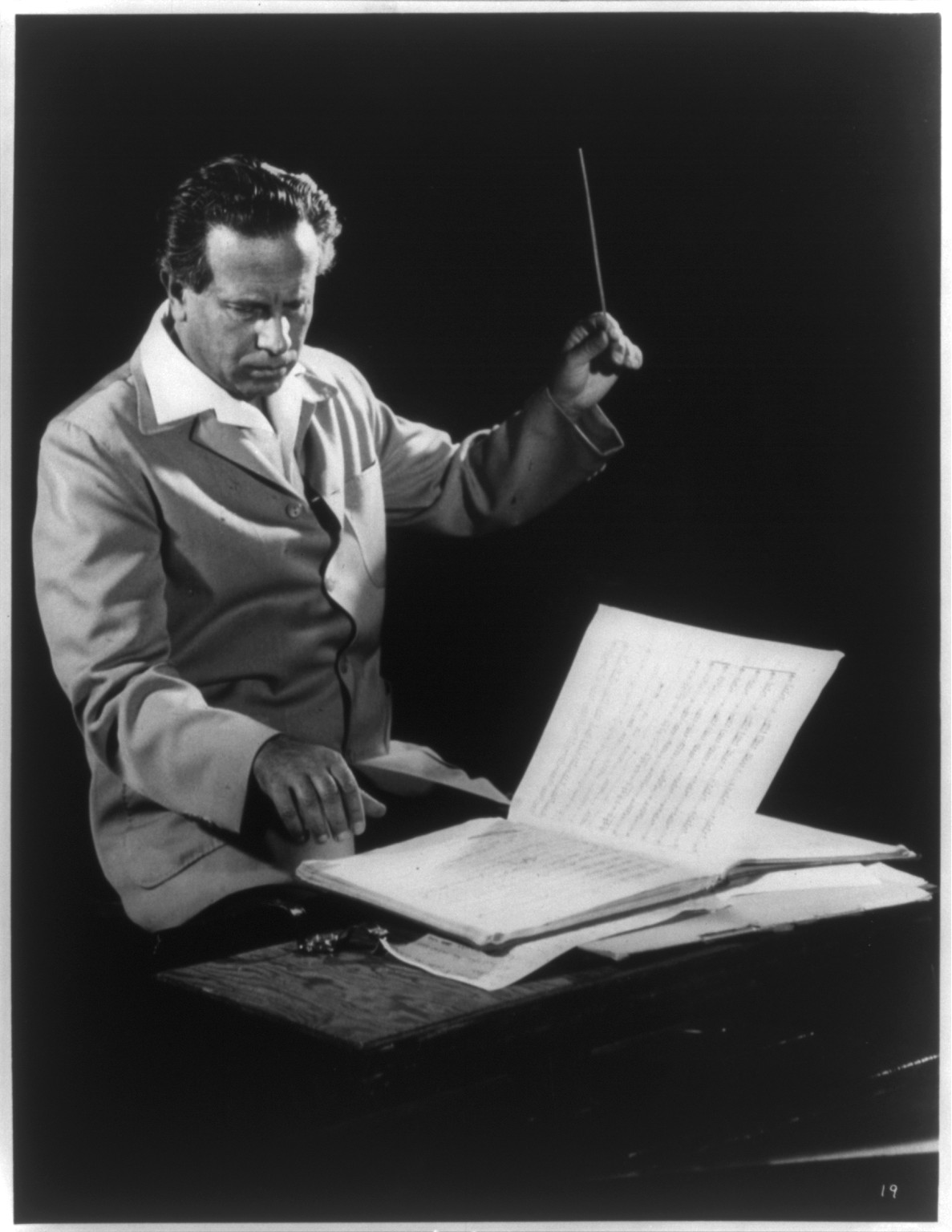 [Antal Dorati, half-length portrait, seated, holding baton and looking at music sheet, facing right] — historic photograph