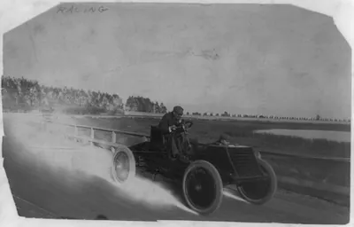 [Winton driving his automobile on racetrack]