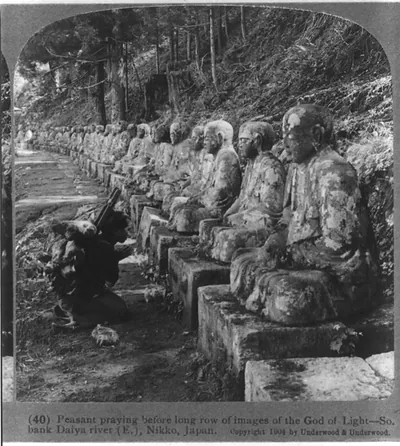 Peasant praying before long row of images of the God of Light - So. bank Diya river (E.), Nikko, Japan.