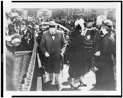 The Churchills go to lunch. Boston: a large crowd greets Winston Churchill (left) and Mrs. Churchill (right of Churchill) as they arrive for a private luncheon at the Odd Volumes Club, April 1, in Boston