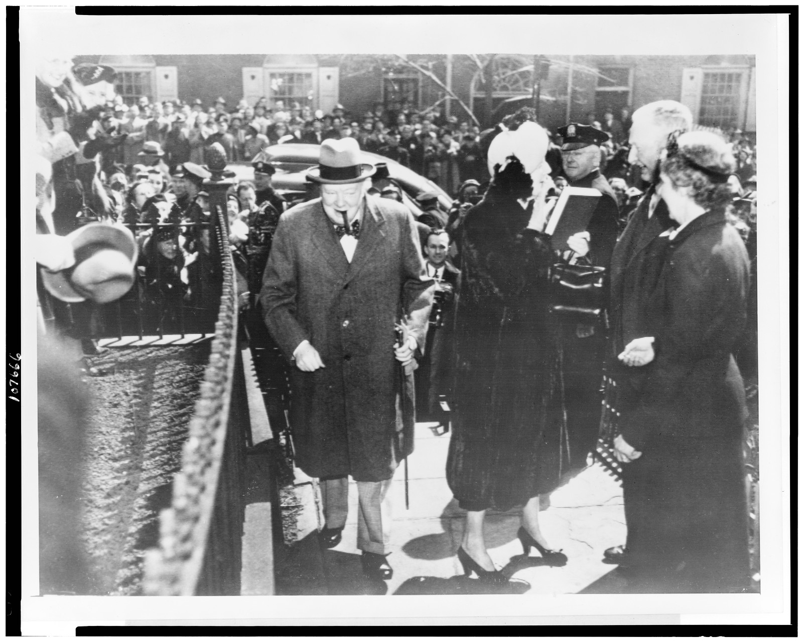 The Churchills go to lunch. Boston: a large crowd greets Winston Churchill (left) and Mrs. Churchill (right of Churchill) as they arrive for a private luncheon at the Odd Volumes Club, April 1, in Boston — historic photograph
