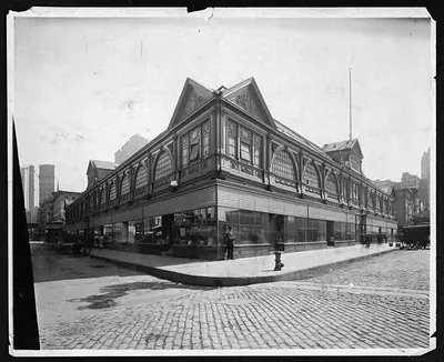Large market building with gabled roofs on a cobbled city street