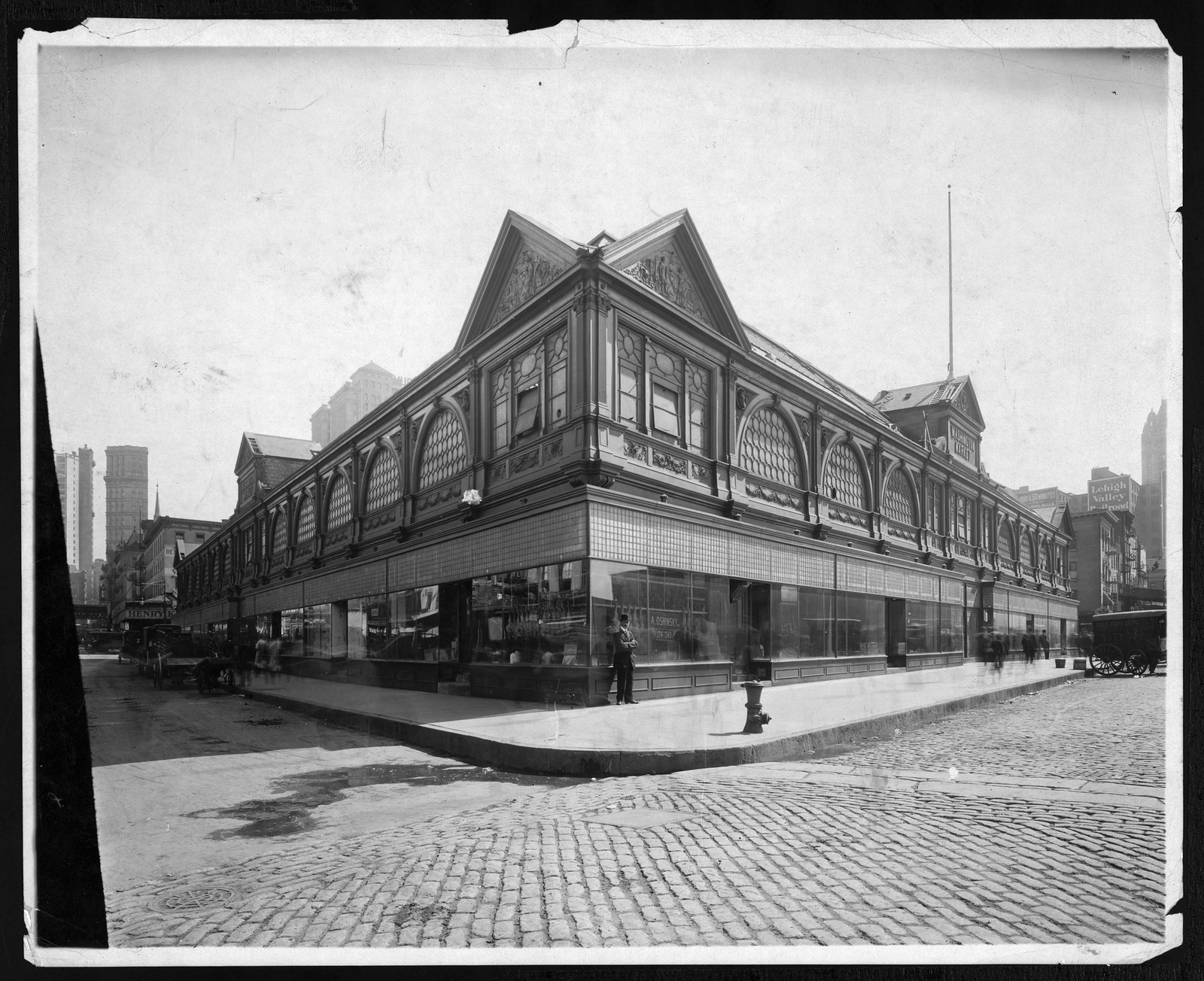 Large market building with gabled roofs on a cobbled city street — historic image