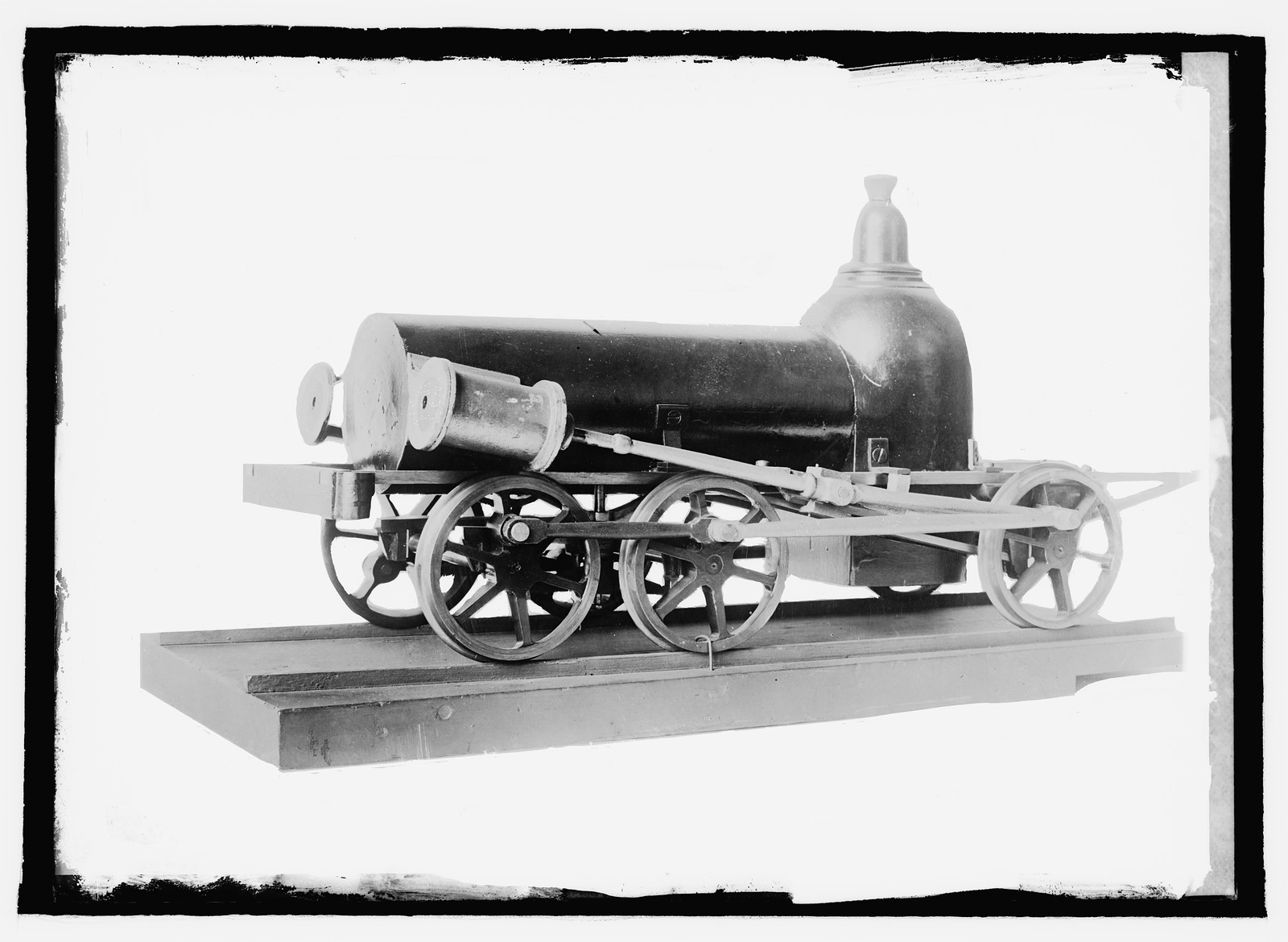 Model steam locomotive on wooden base, black and white photograph — historic photograph