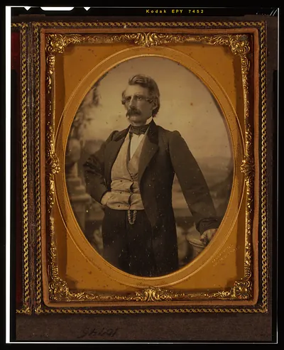 [Unidentified man, three-quarters length portrait, standing in front of painted backdrop]