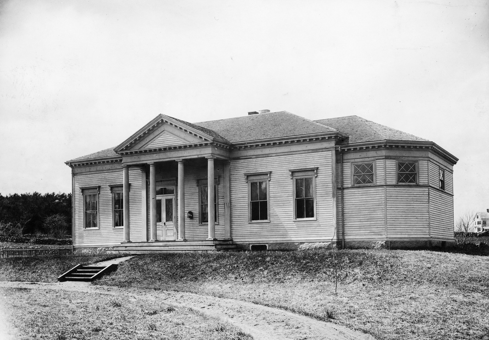 Classical wooden building with columned front porch — historic image