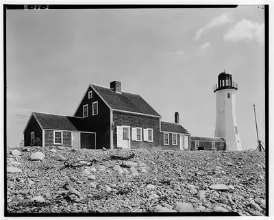 Shingled keeper's house and lighthouse on a rocky shore