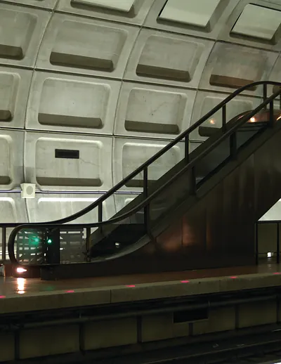 Escalator in a metro station with coffered concrete ceiling