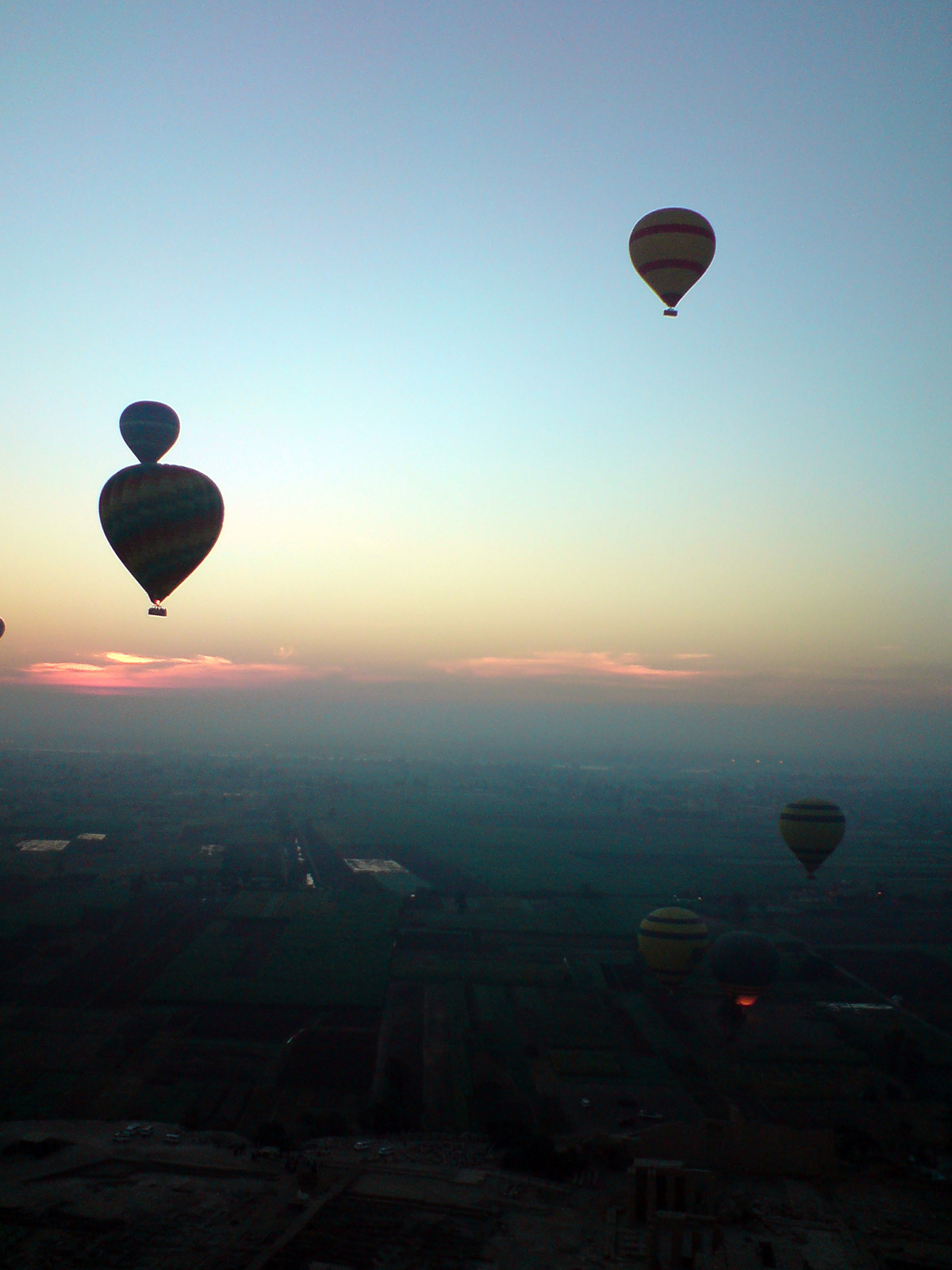 Hot-air balloons at dawn over flat farmland — historic image