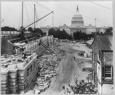 [View of construction of the basement and first floor of the Library of Congress on the north side, with the U.S. Capitol in the background]