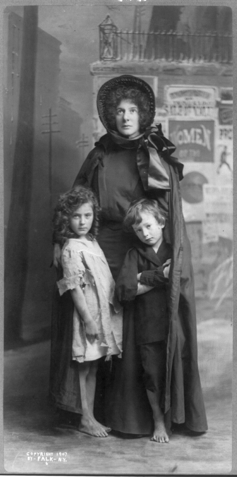 [Evangeline Cory Booth, 1865-1950, standing, in Salvation Army dress, facing front; with 2 children], c1907 Dec. 19. — historic photograph