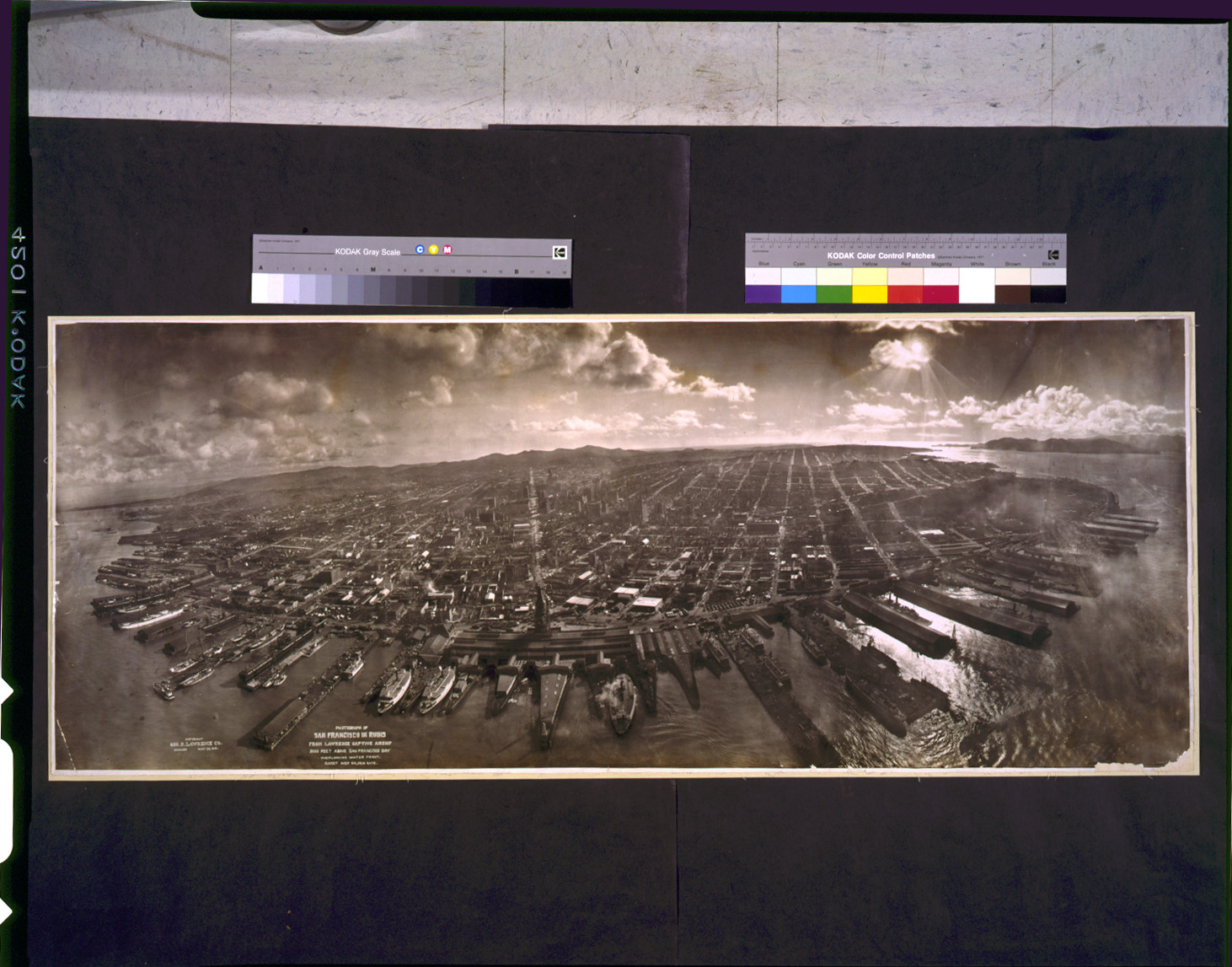 Photograph of San Francisco in ruins from Lawrence Captive Airship, 2000 feet above San Francisco Bay overlooking water front. Sunset over Golden [Gat]e, c1906. — historic photograph