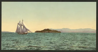 Schooner sailing past an island, hand-colored print