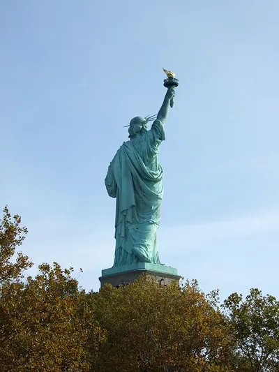 Statue of Liberty seen from behind against blue sky