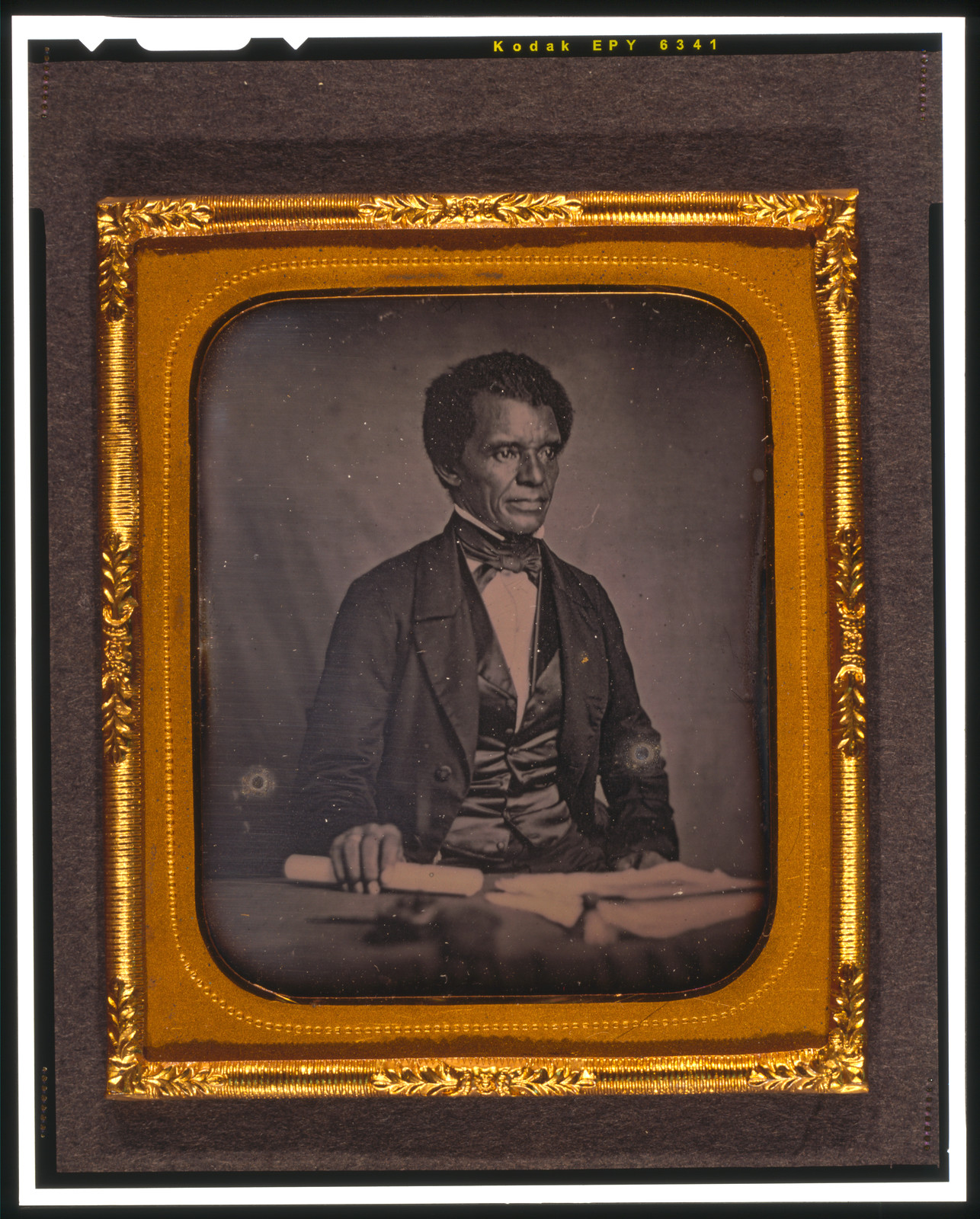 [Beverly Page Yates, half-length portrait, facing slightly right, seated at table, holding rolled piece of paper], [between 1856 and 1860] — historic photograph