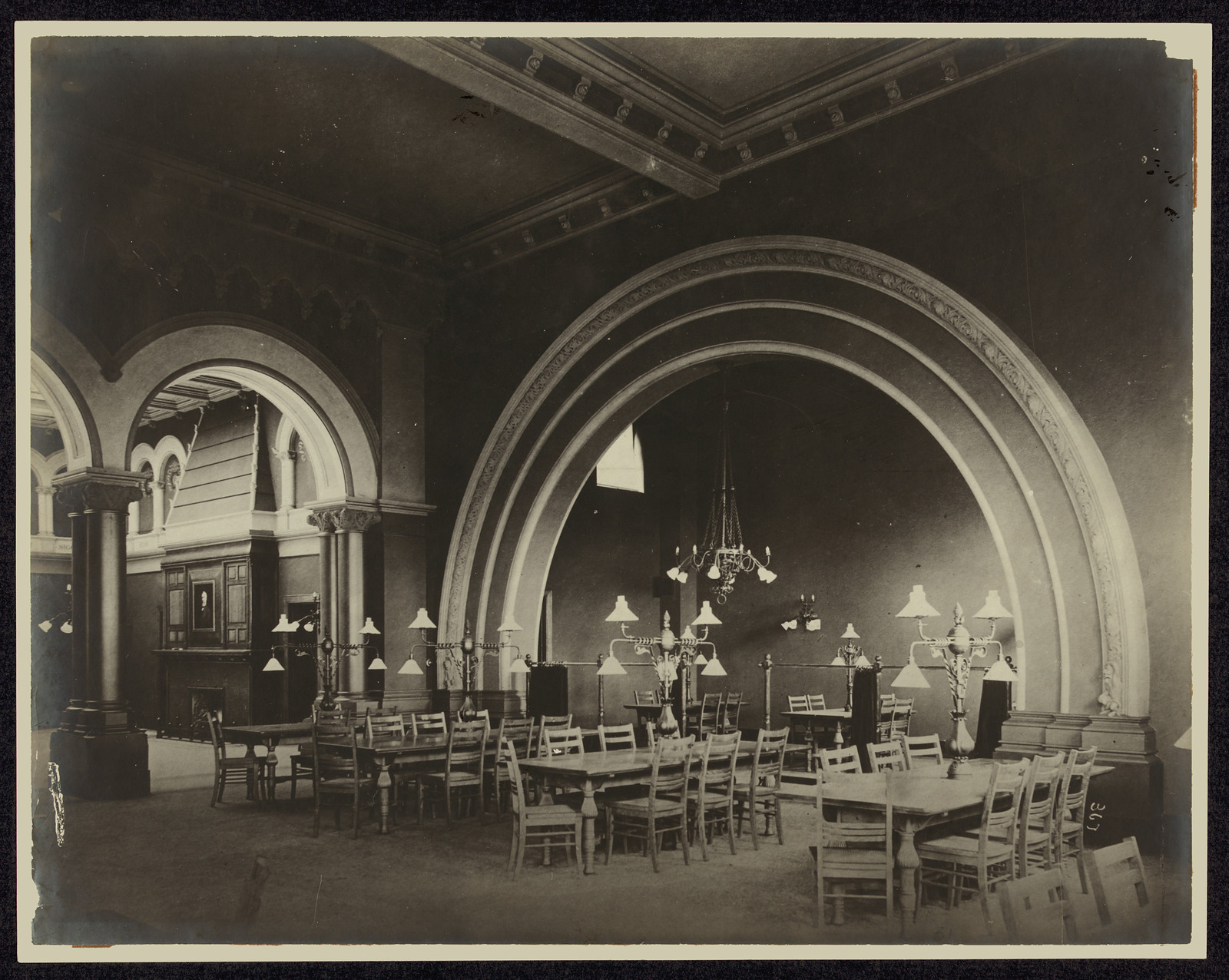 Reading room interior with arches, tables and chandeliers — historic image