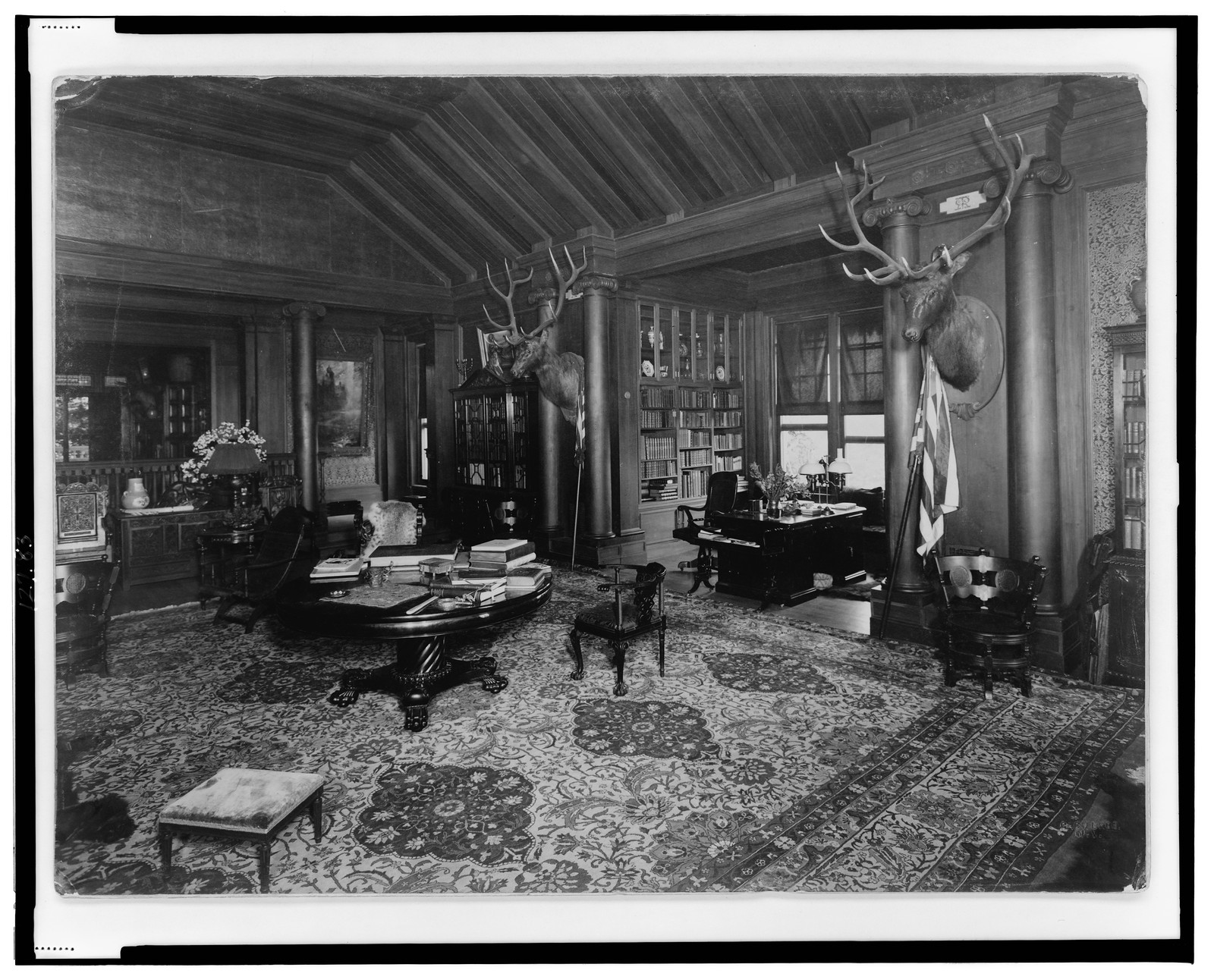[Library(?) at Theodore Roosevelt's home, Sagamore Hill, Long Island, with two elk heads on wall], c1910. — historic photograph