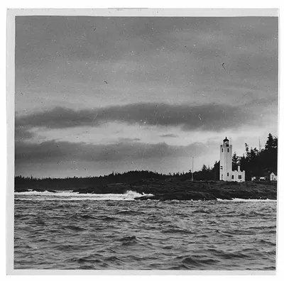 White lighthouse on rocky coast with stormy sea