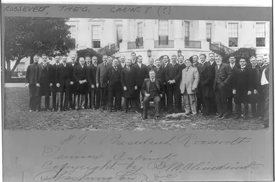 [Theodore Roosevelt, full, seated, on White House lawn flanked by Tennis Cabinet" of 30 men]"